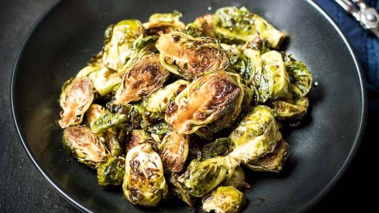 Roasted balsamic glazed brussels sprouts in a black bowl.