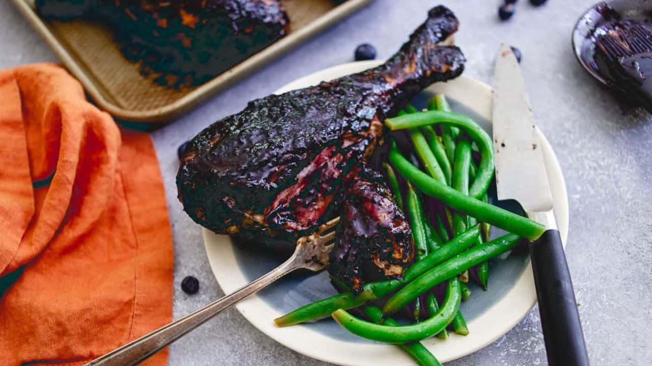 Blueberry BBQ turkey legs on a baking sheet.