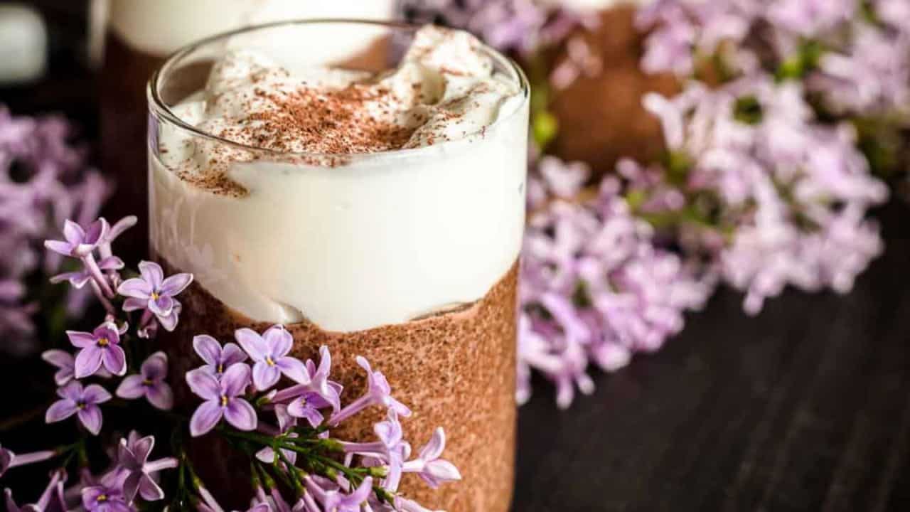 Keto Chia Seed Chocolate Pudding with yogurt and purple flowrs.