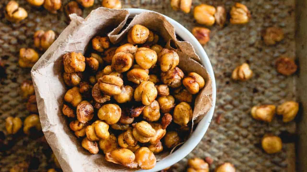 Cinnamon crunch roasted chickpeas in a bowl with more scattered around.