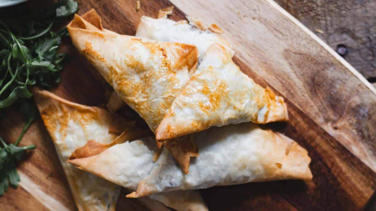 Stuffed mushrooms on a wooden cutting board.