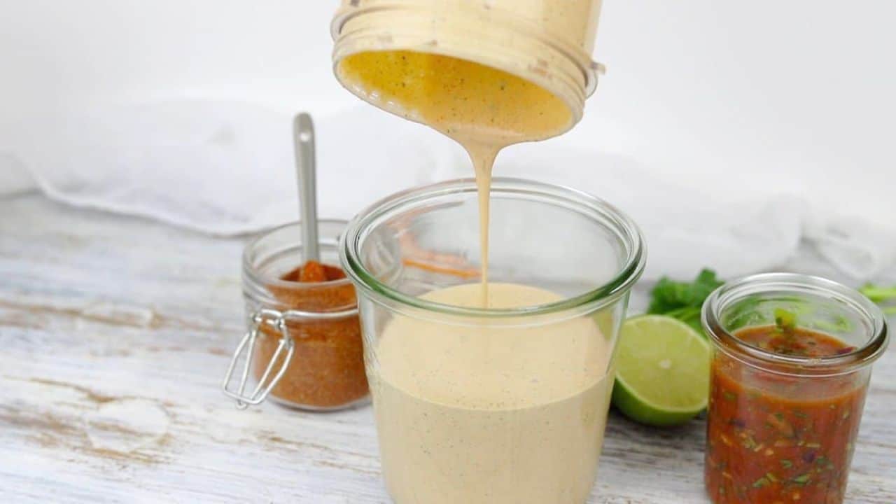 Easy Healthy Creamy Salsa Dressing in a dish with a spoon dishing it up.