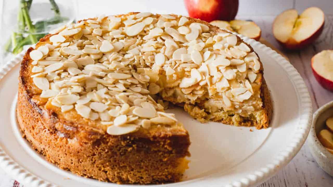 A plate of apple pie with a slice taken out of it.