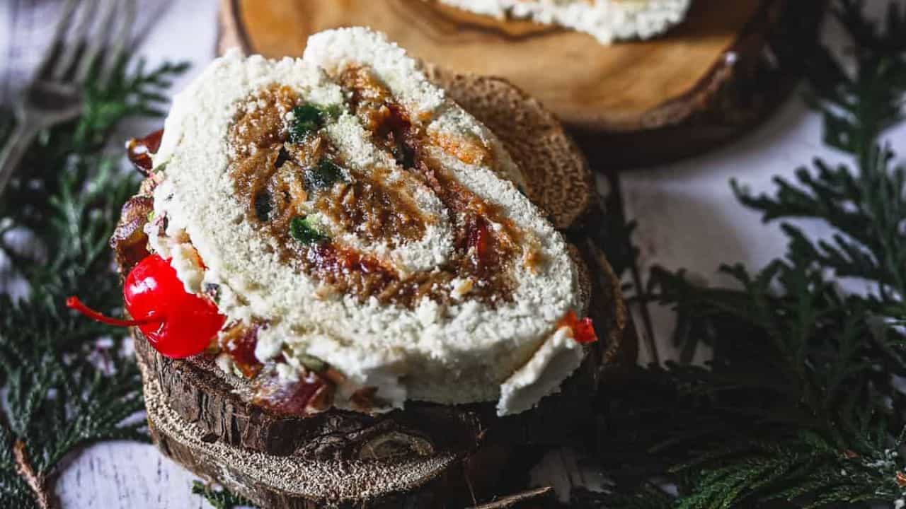 A christmas tree shaped cake on a wooden board.