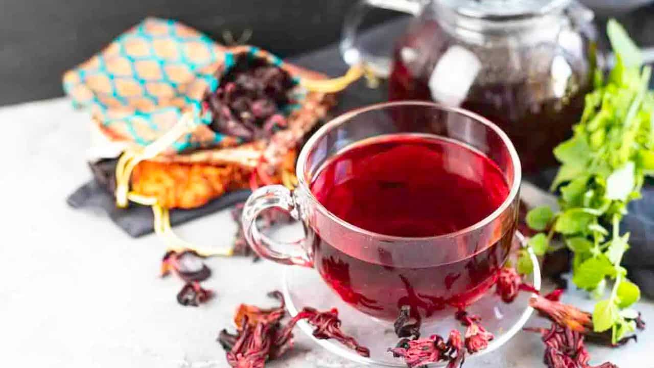 A clear glass cup of hibiscus tea.