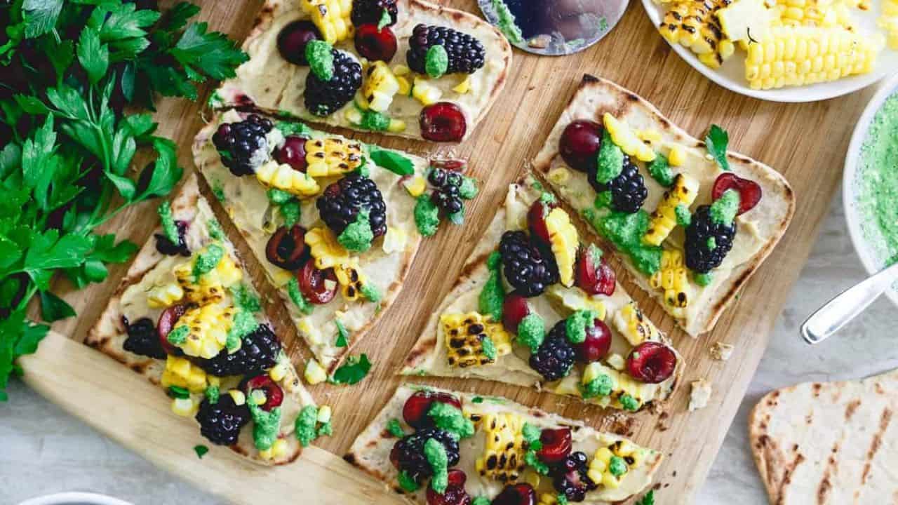 Grilled hummus flatbread with fruit and corn.