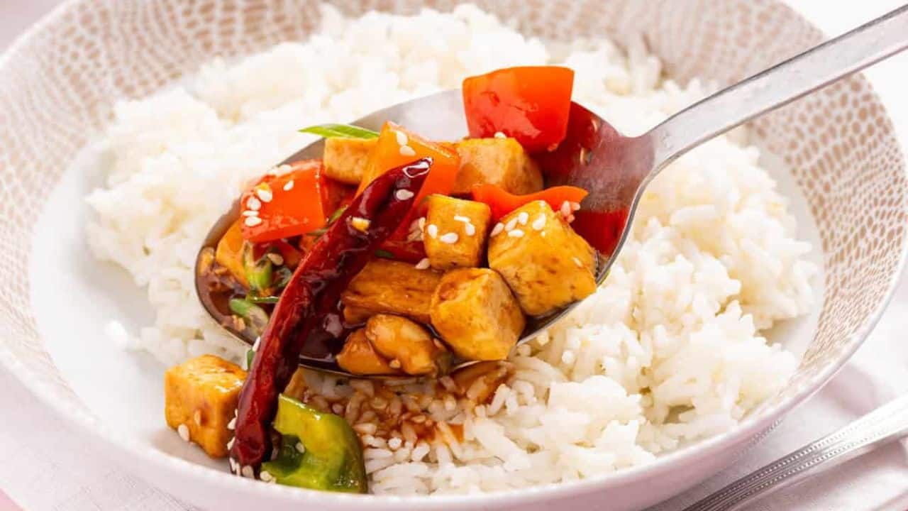 An image of kung pao tofu served in a bowl over rice.