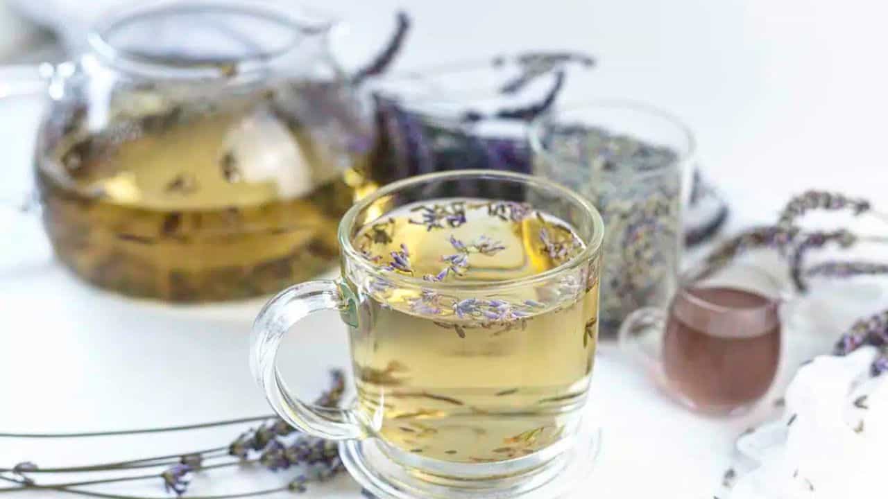 A clear glass cup filled with lavender tea.