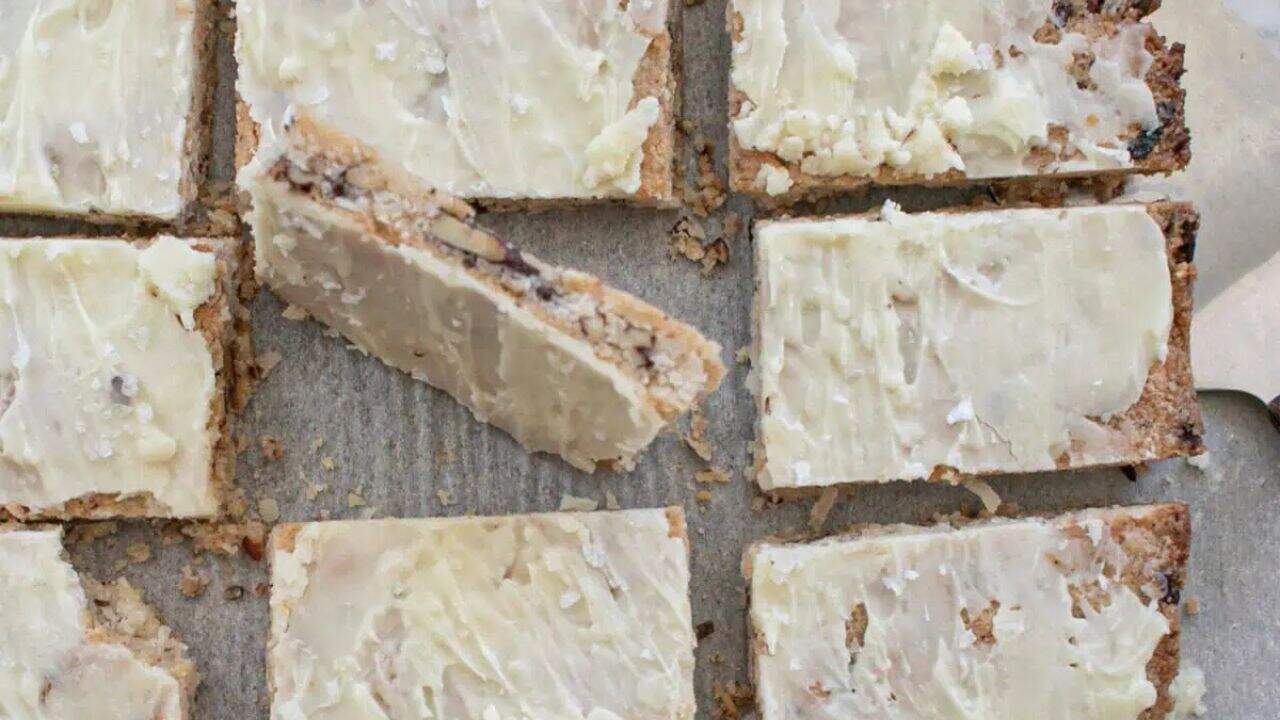 A plate full of magic cookie bars that are frosted.