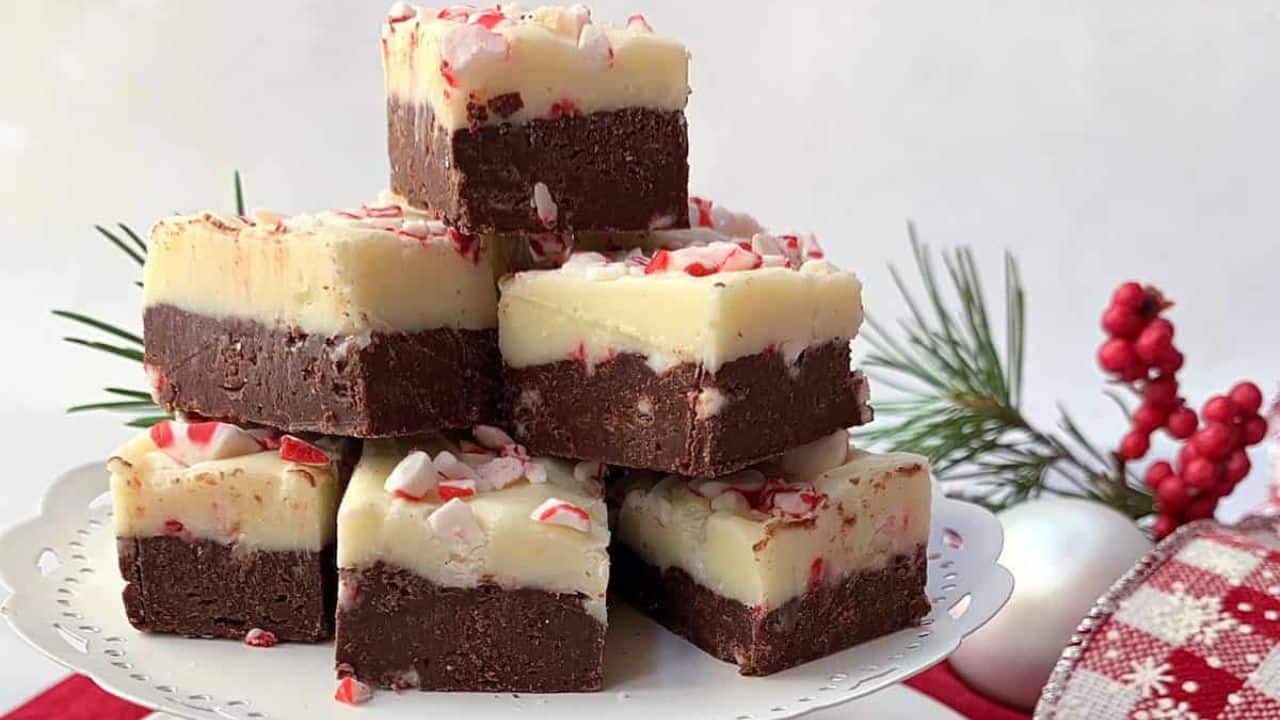Two layer mint fudge on a piece of parchment paper on a white board.