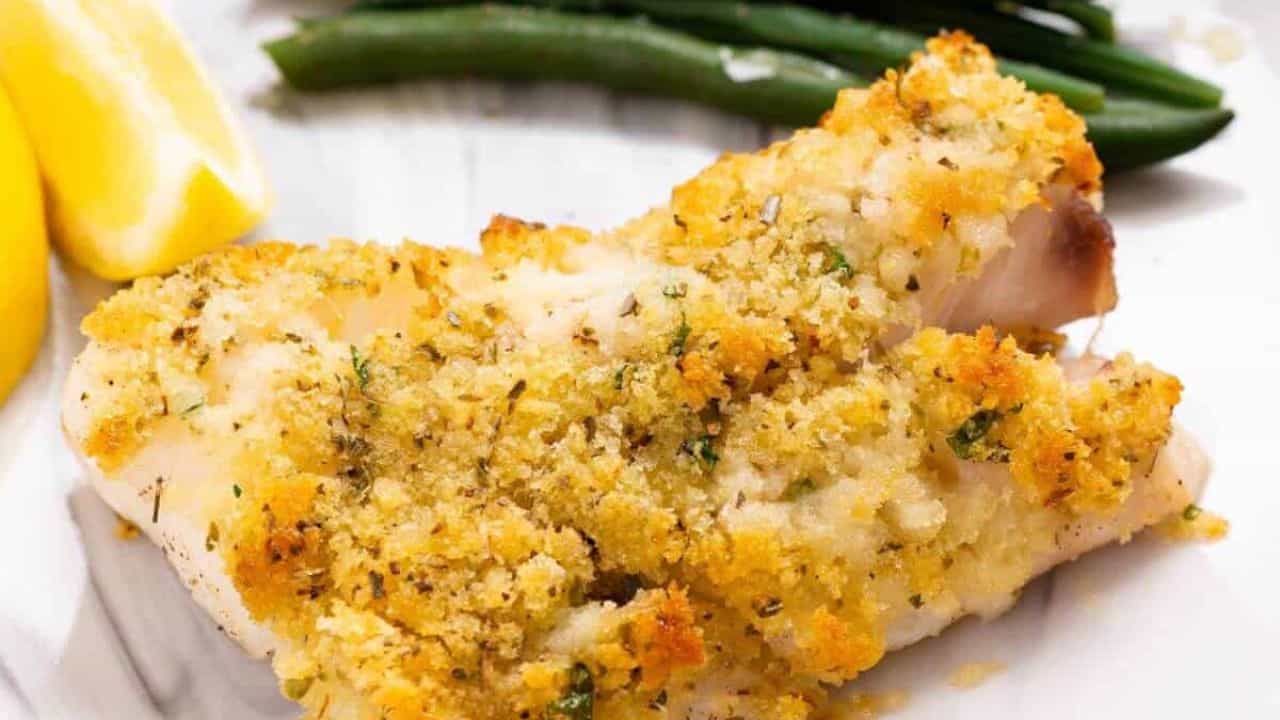Panko-crusted cod fish on a plate with green beans.