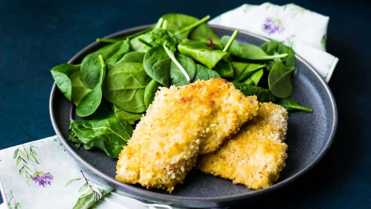 panko crusted rockfish on a plate with spinach.