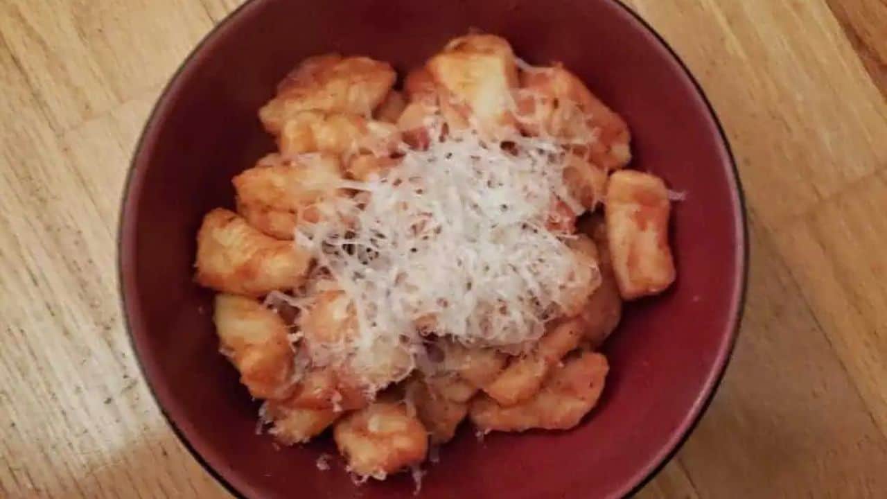 Image shows a bowl of Potato Gnocchi with grated cheese atop it.