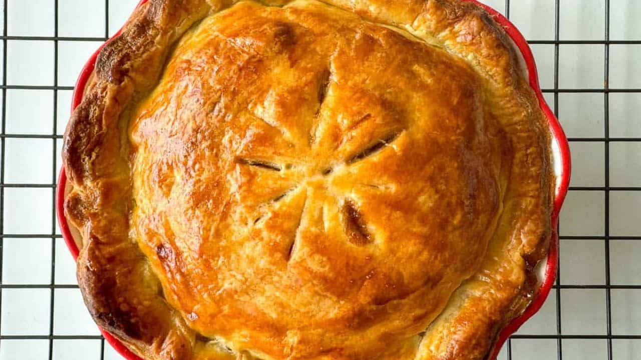 A lightly browned pie on a cooling rack.