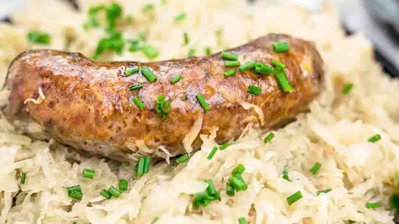 A cooked sausage on a sauerkraut plate.