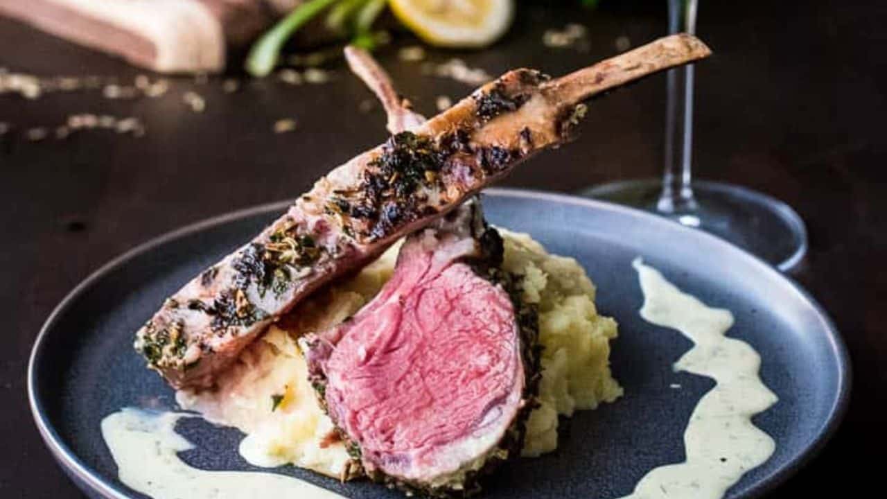 Roasted rack of lamb on a cutting board.