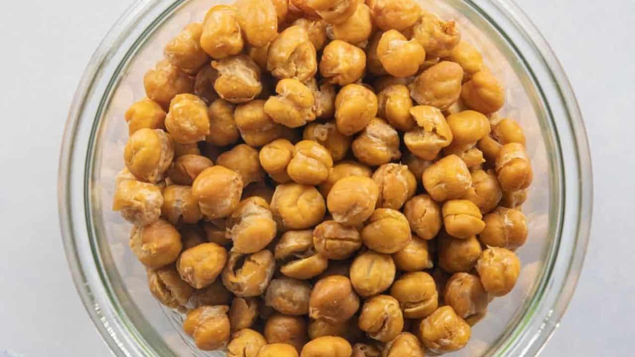 A top-down view of a glass bowl filled with roasted chana.