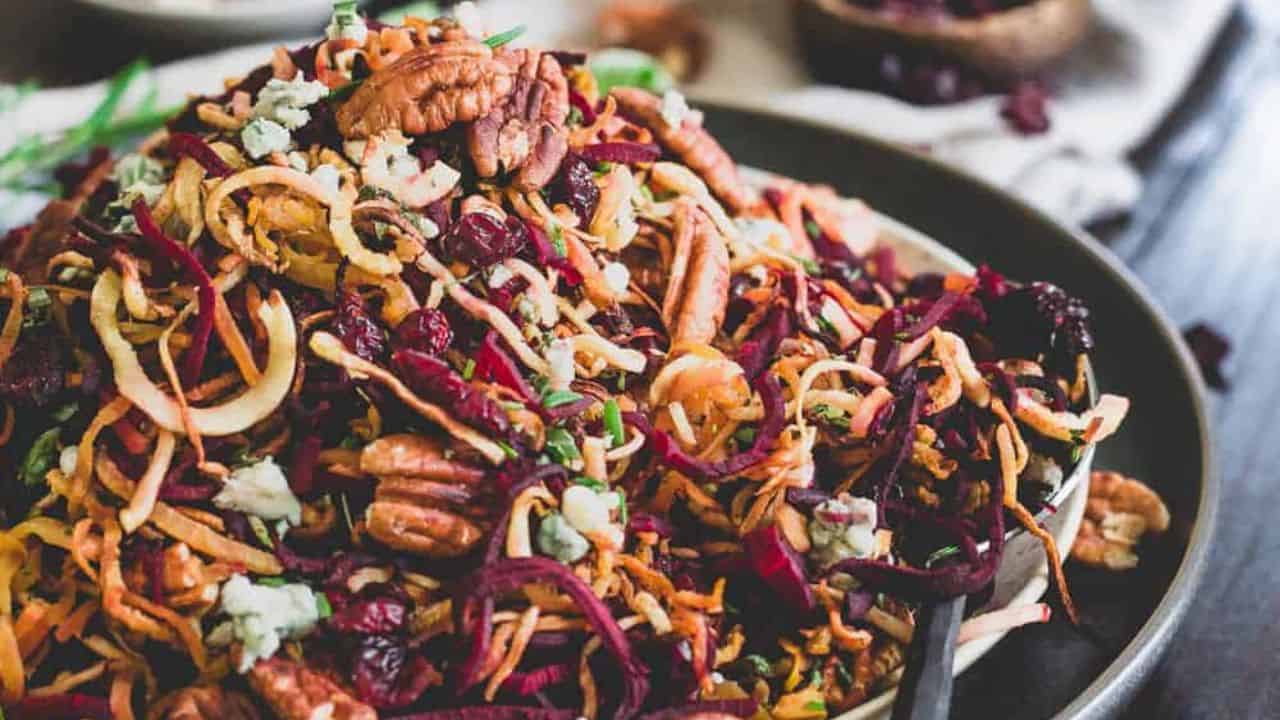 Winter root vegetable salad on a plate with fresh rosemary and sage.