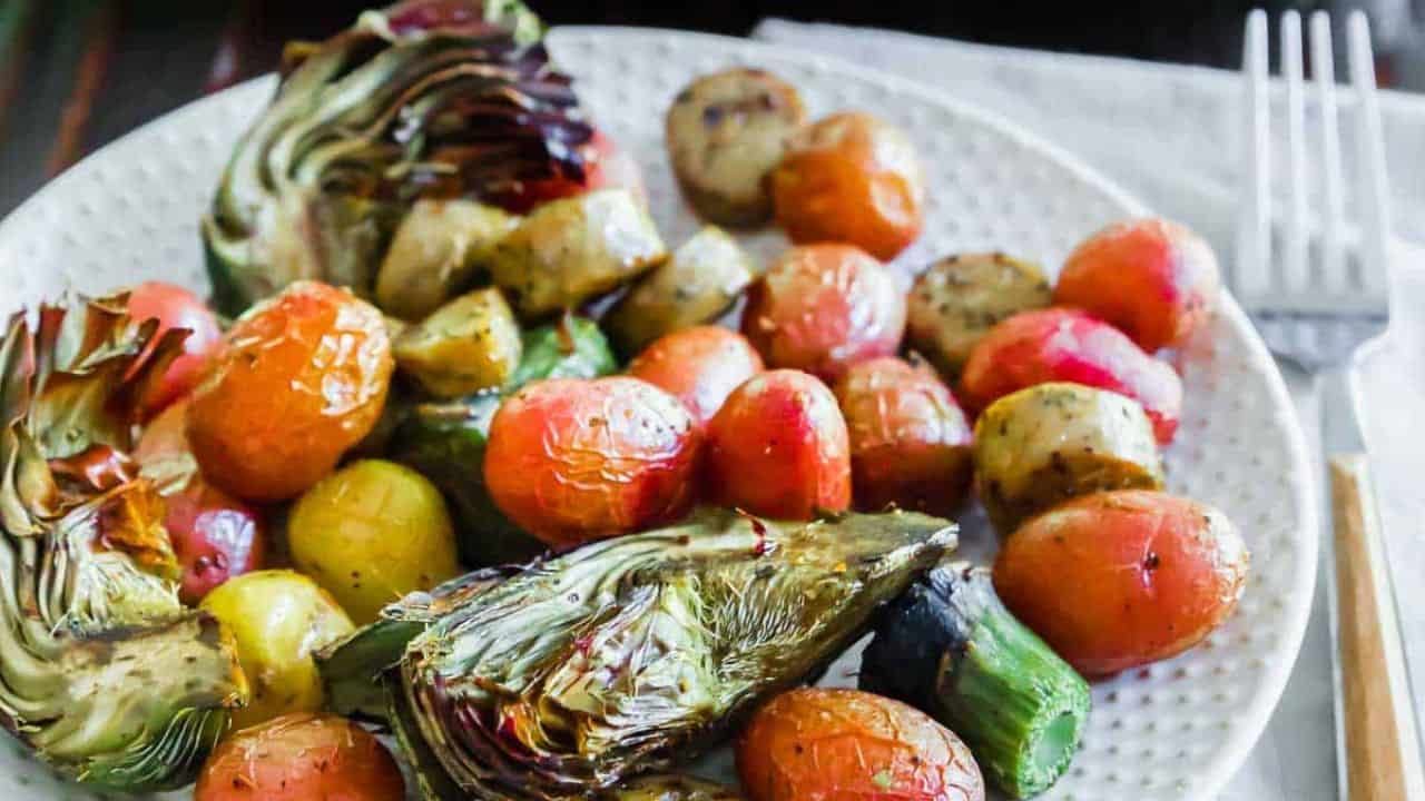 Chicken sausage and vegetables on a baking sheet.
