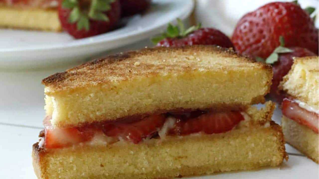 A white plate with a strawberry grilled cheese sandwich.