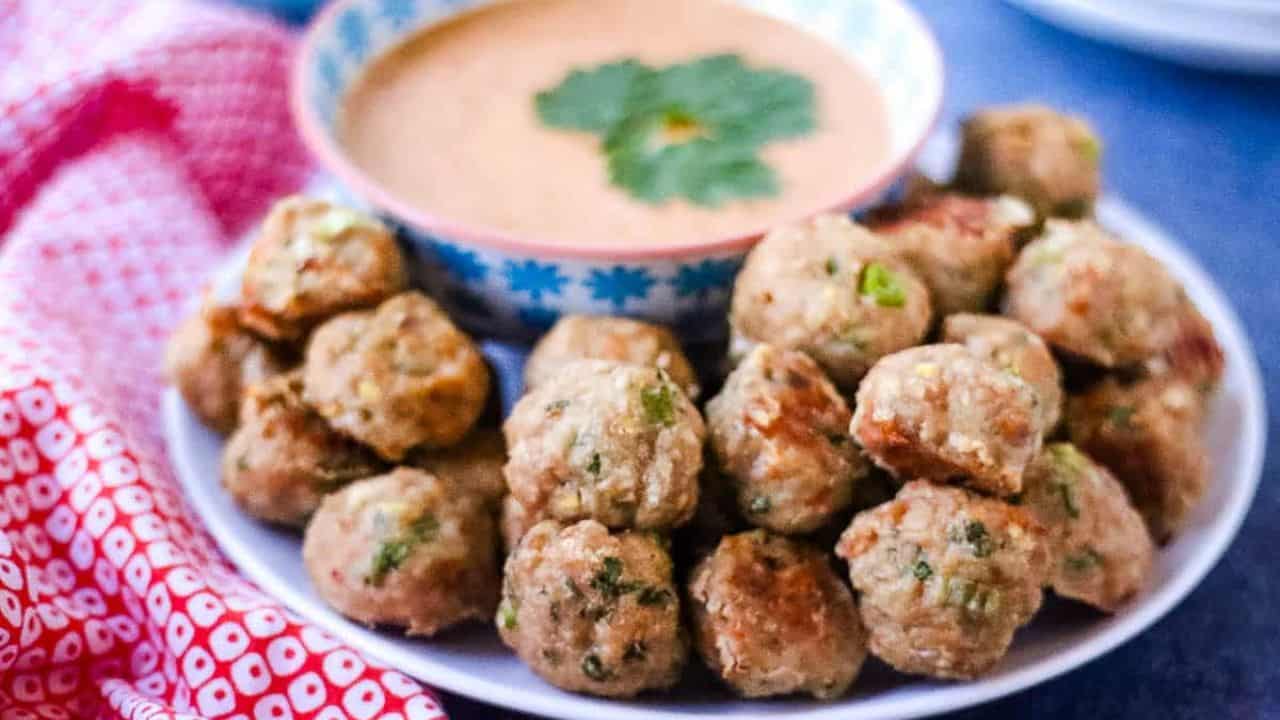 Thai turkey meatballs on a platter with red curry dipping sauce.