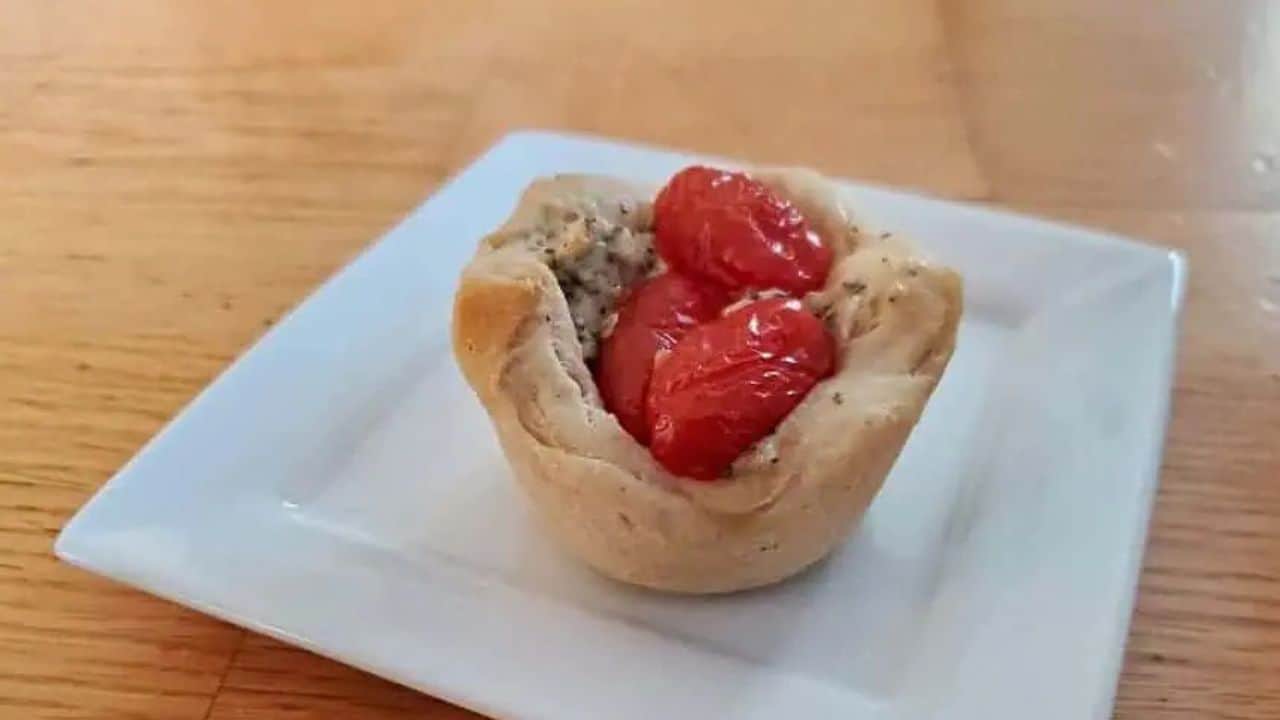 Image shows a Tomato Basil Biscuit Cup on a white plate.