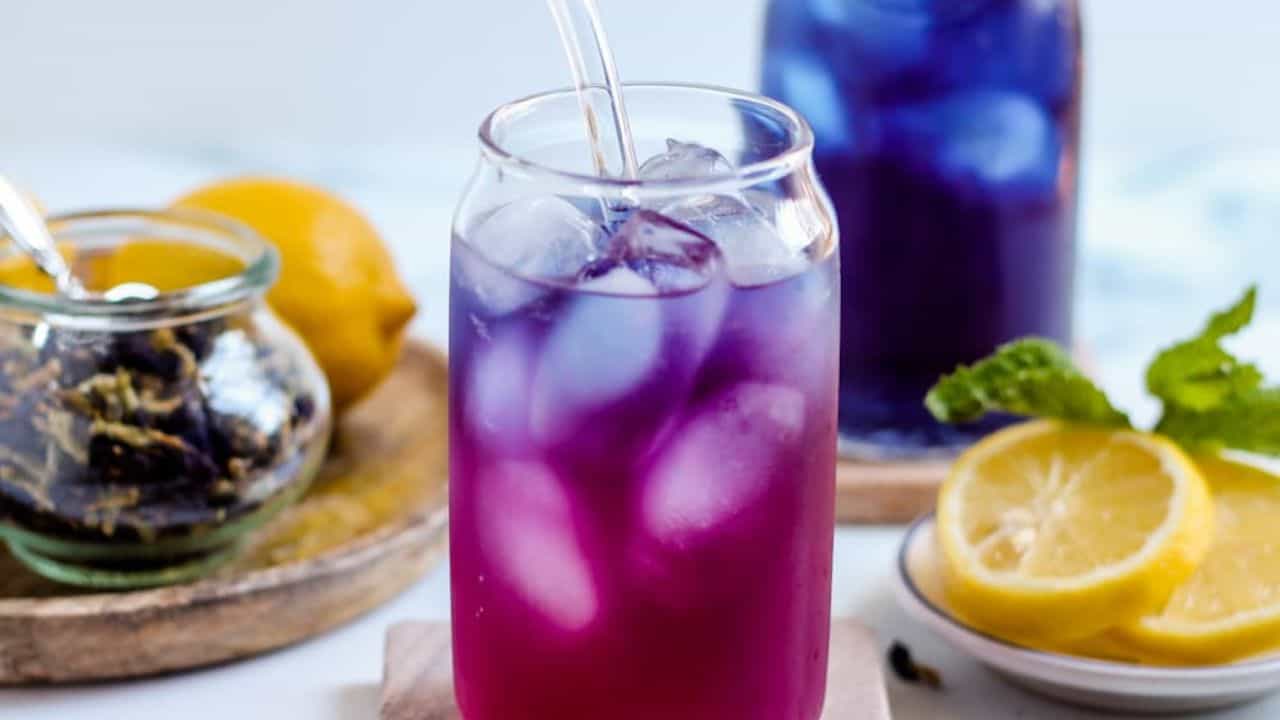 A glass of butterfly pea tea over ice.