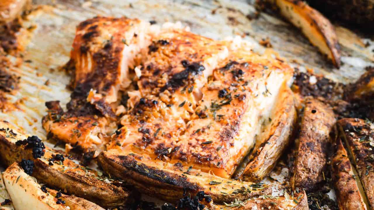 Grilled salmon and potatoes on a baking sheet.