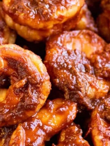 Close-up of cooked shrimp coated in a thick, reddish-brown spicy sauce.