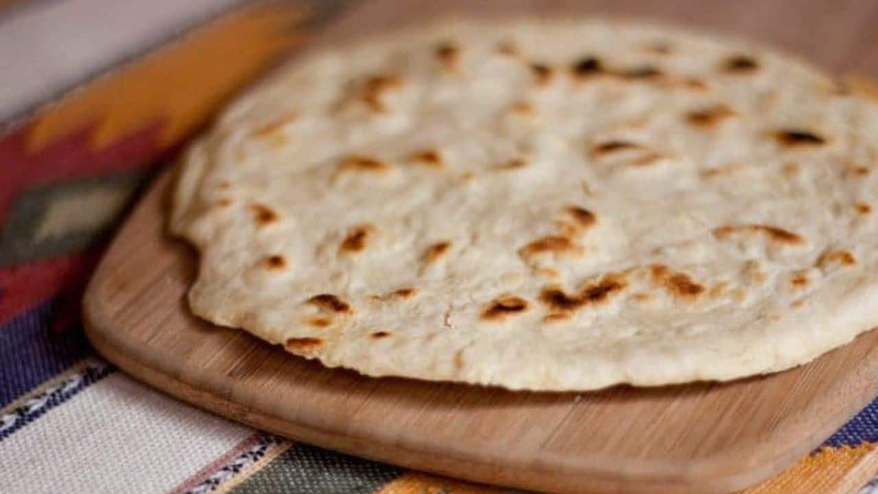 Flour tortillas stacked on a plate.