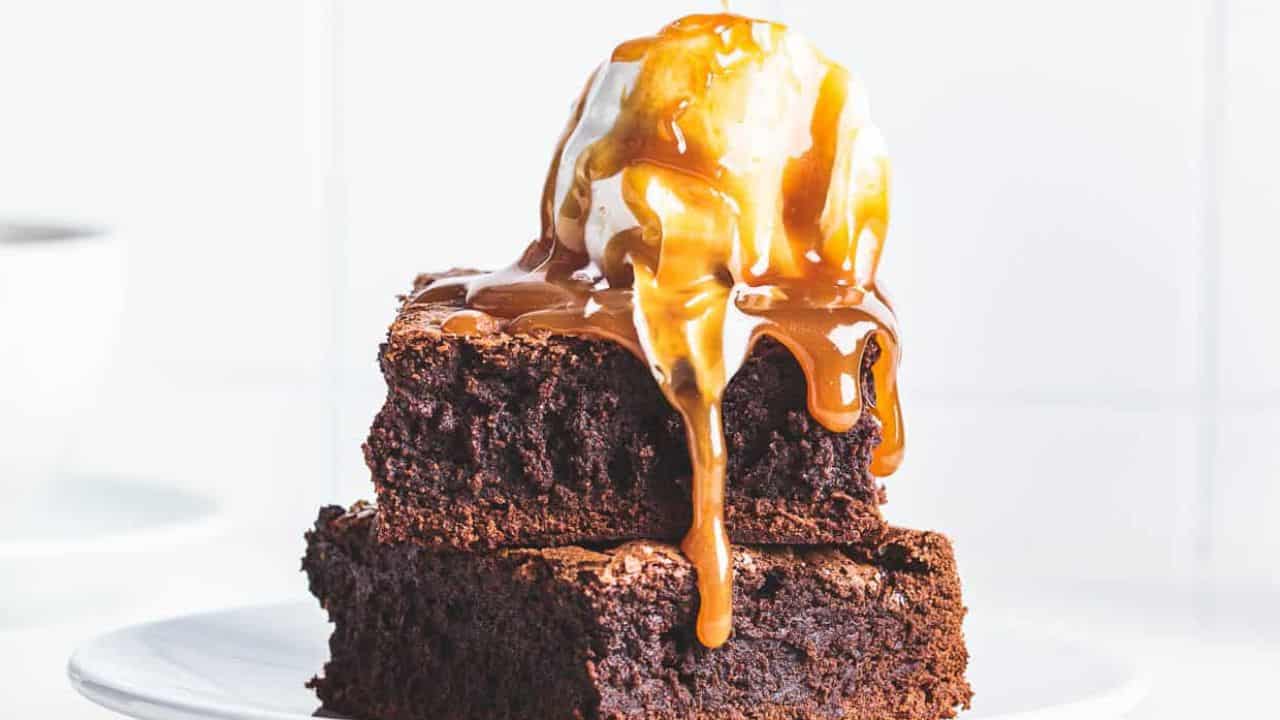 Brownies and ice cream with miso caramel being drizzled over the top.