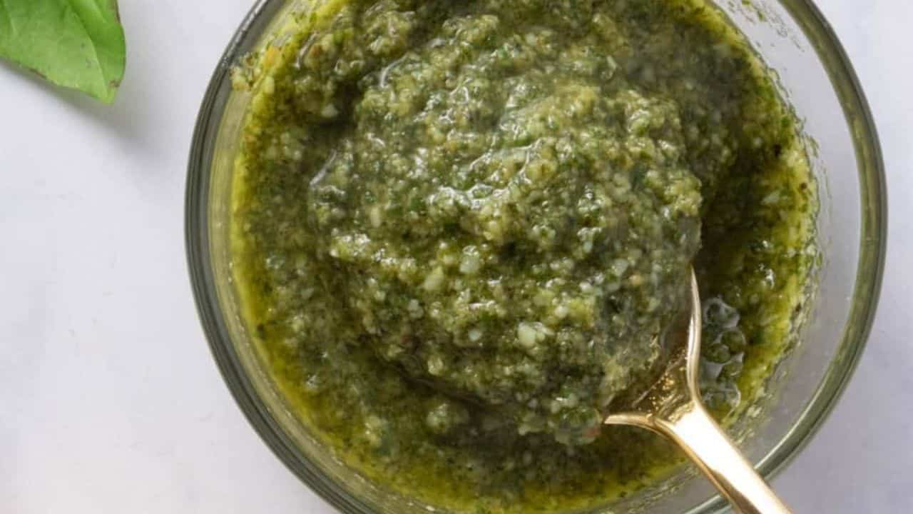 A close up image of basil pesto in a bowl.