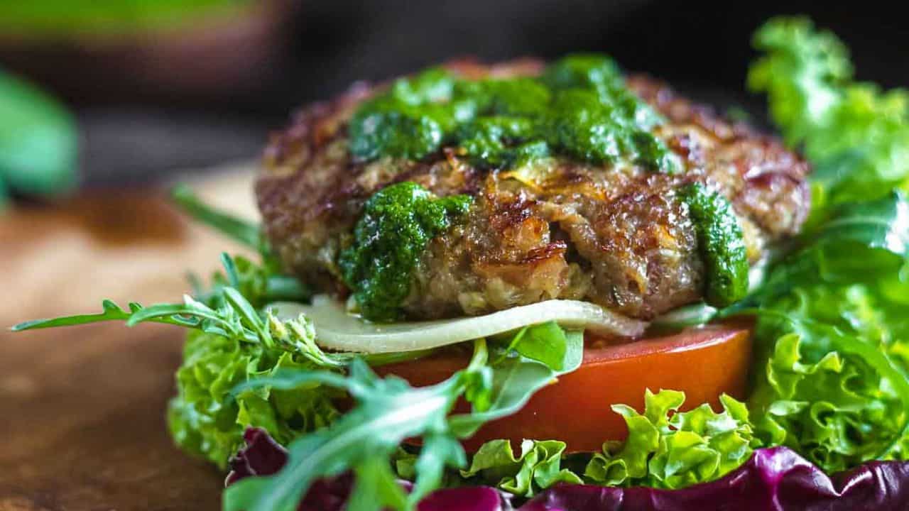 Burger without a bun with green sauce.