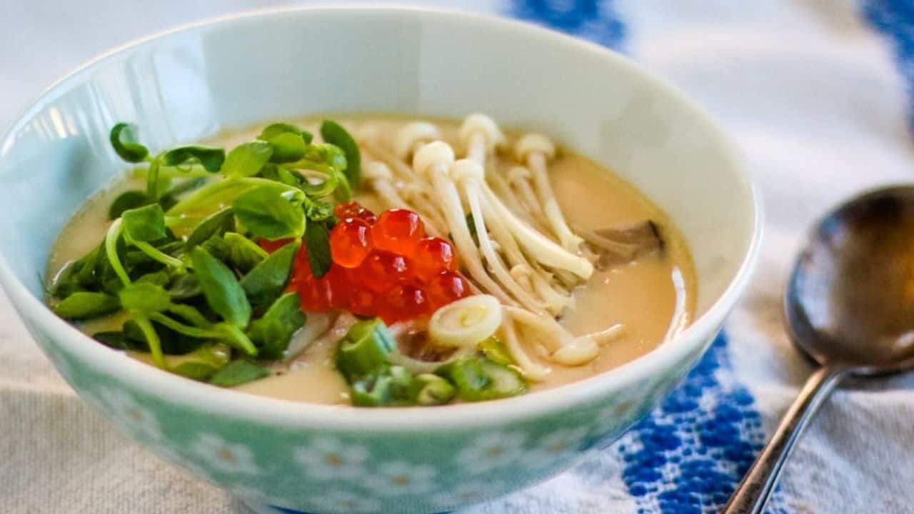 Overhead shot of two bowls of chawanmushi with garnishes.