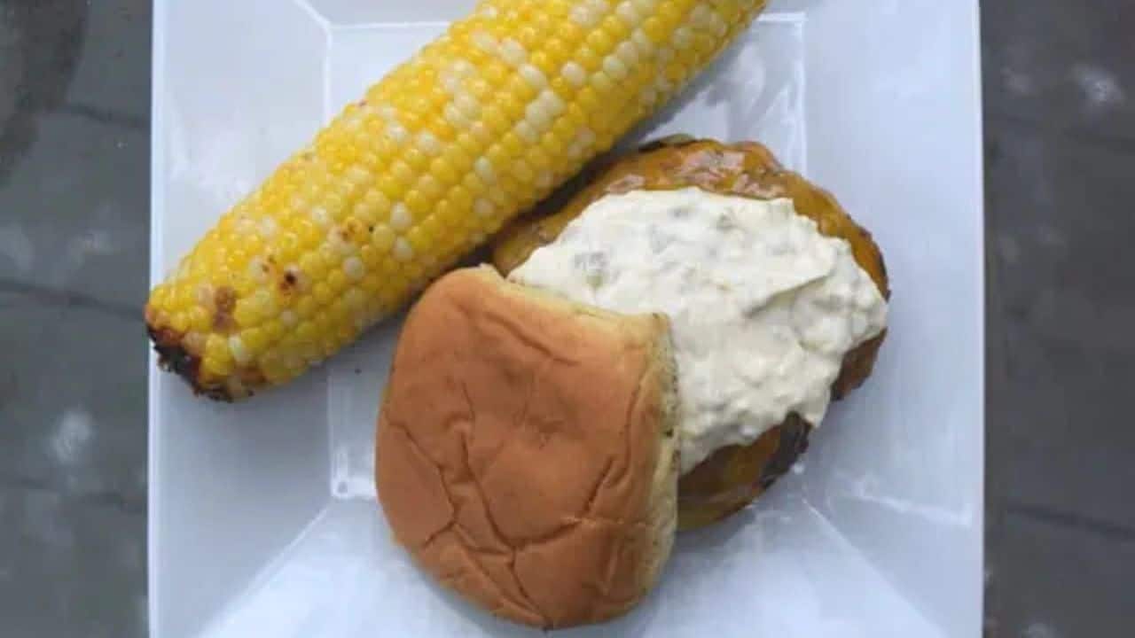 Image shows a Chipotle burger with grilled corn in the background.