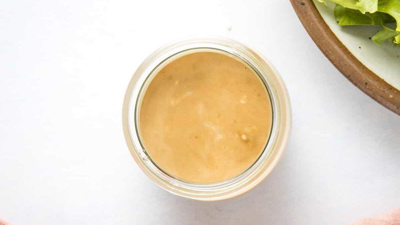 A top-down view of a jar filled with a creamy japanese sesame dressing.