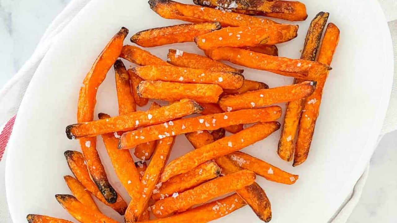 A plate of air-fried sweet potato fries sprinkled with salt.