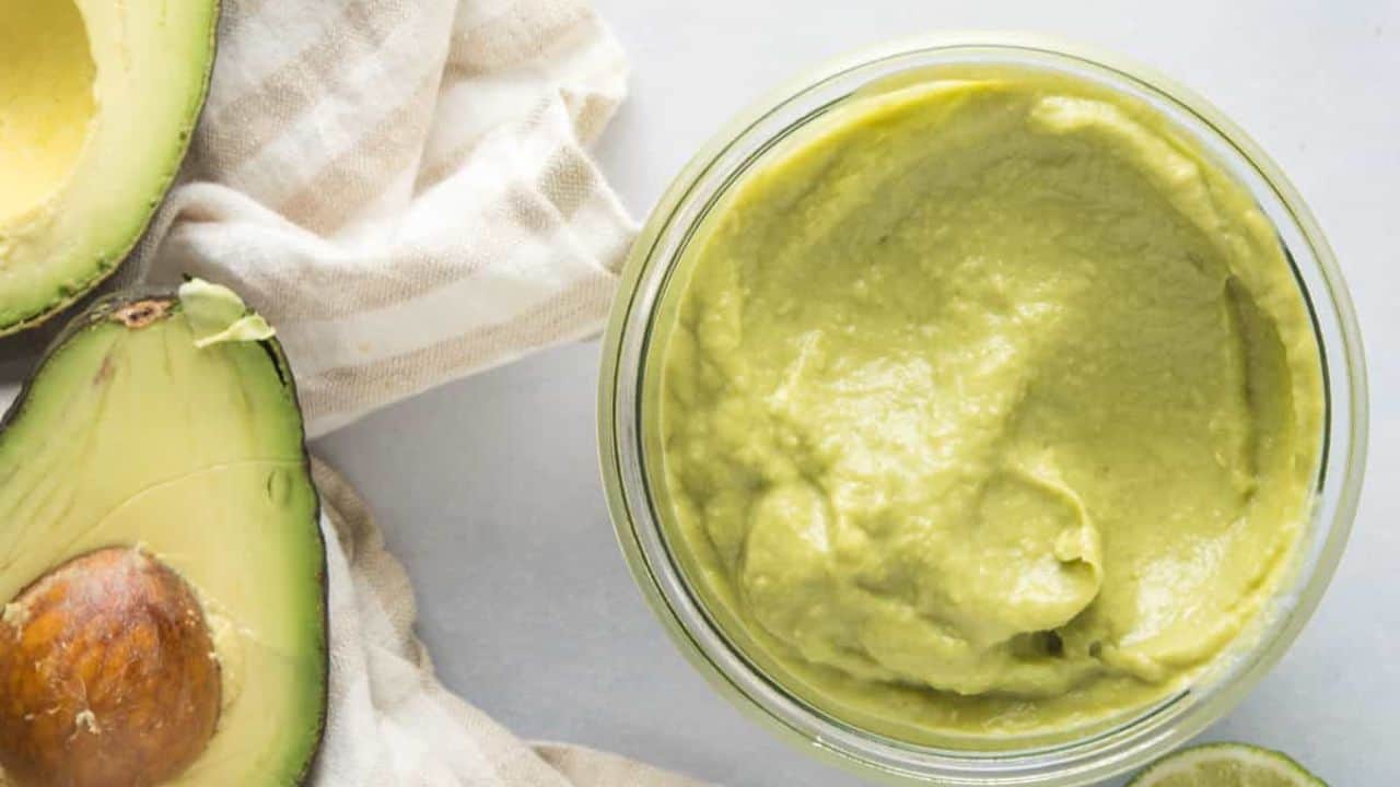 A glass jar filled with guacamole salsa.