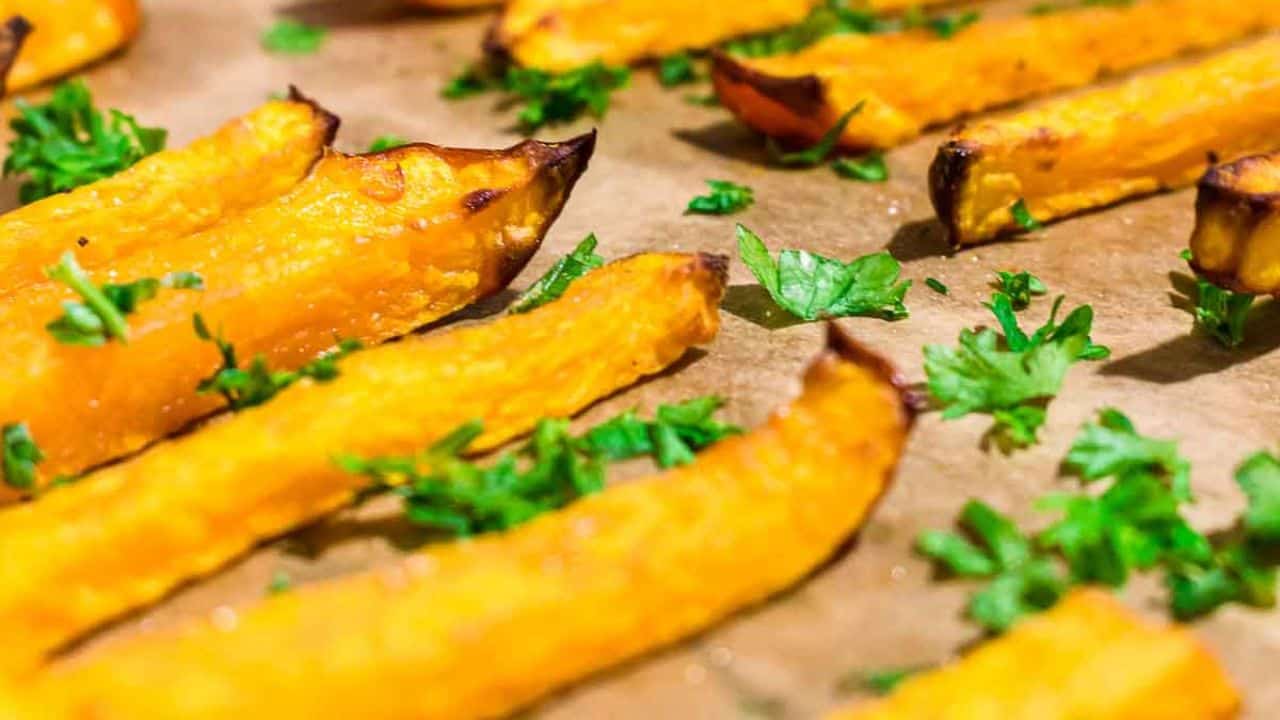 Pumpkin Fries on a parchment paper with herbs.