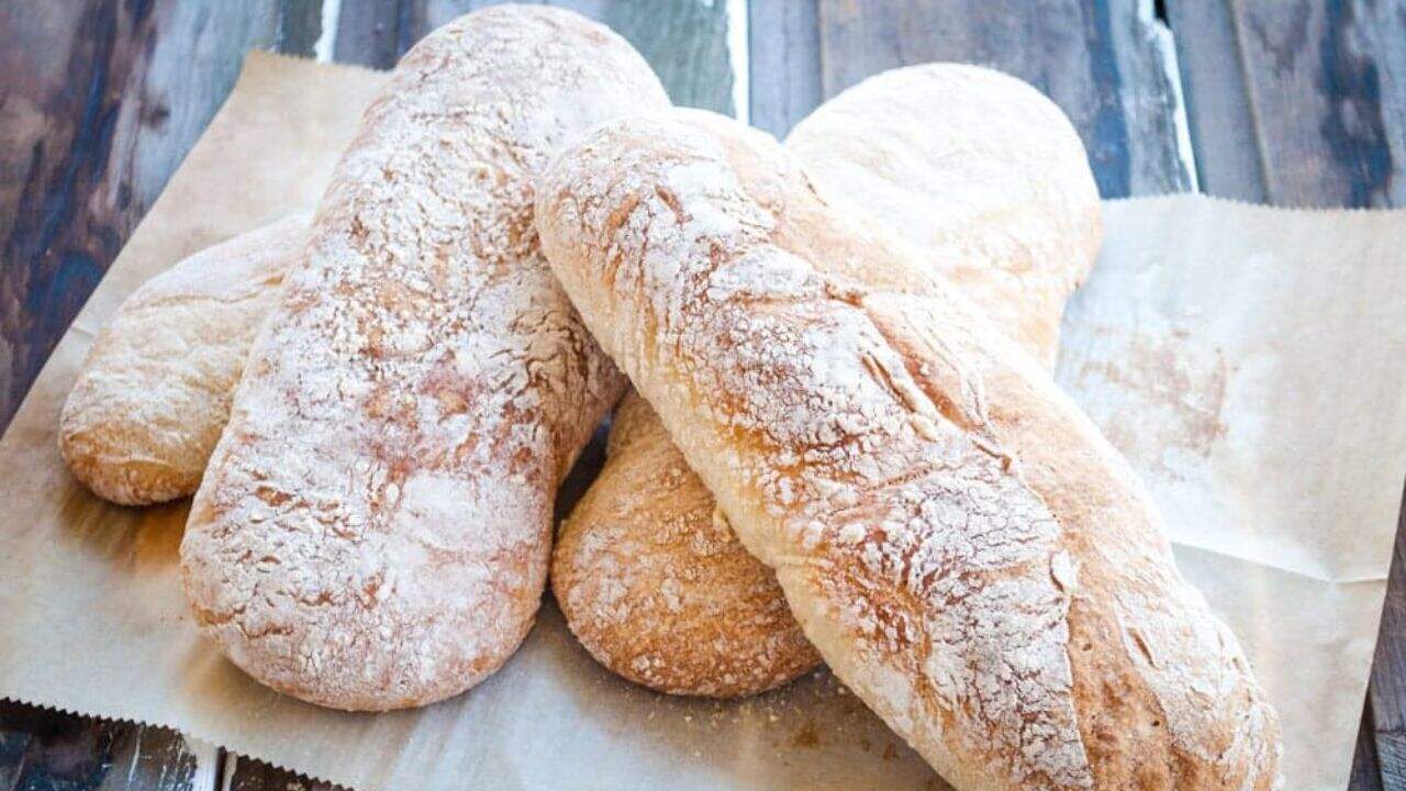 Rustic bread on parchment paper on a wood surface.