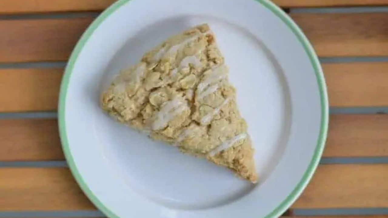 Image shows a Chai Scone on a white plate sitting on a wooden table.