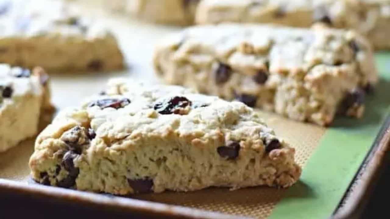 Image shows Cherry Chip Scones on a baking sheet with the sun coming in from the back.