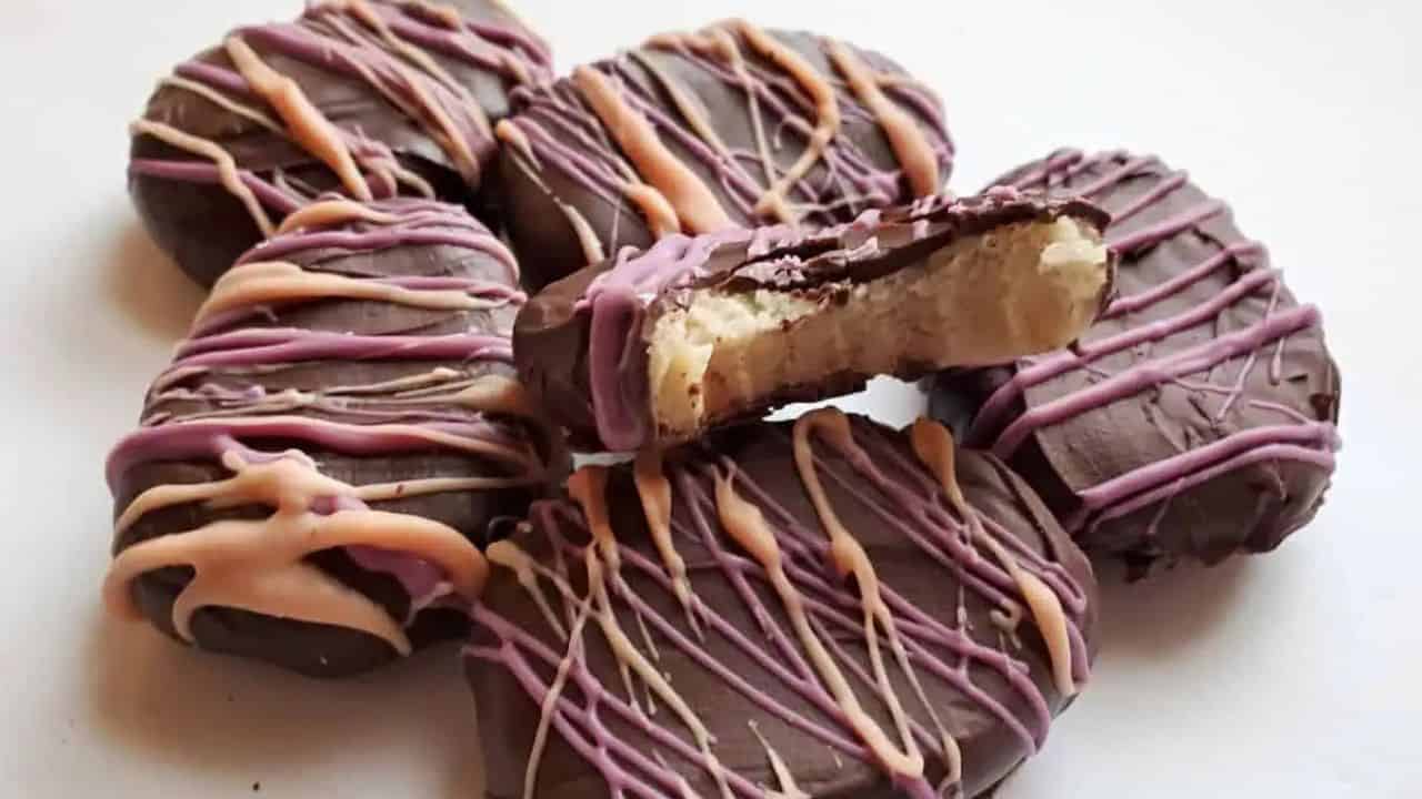 Image shows a cluster of easter egg truffles with one missing a bite and showing the cookie dough inside.