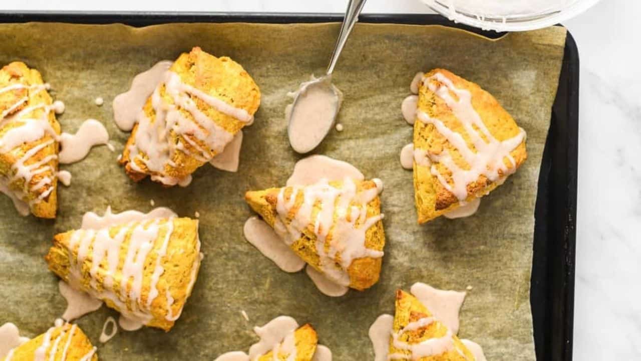 Glazed scones on a baking sheet.