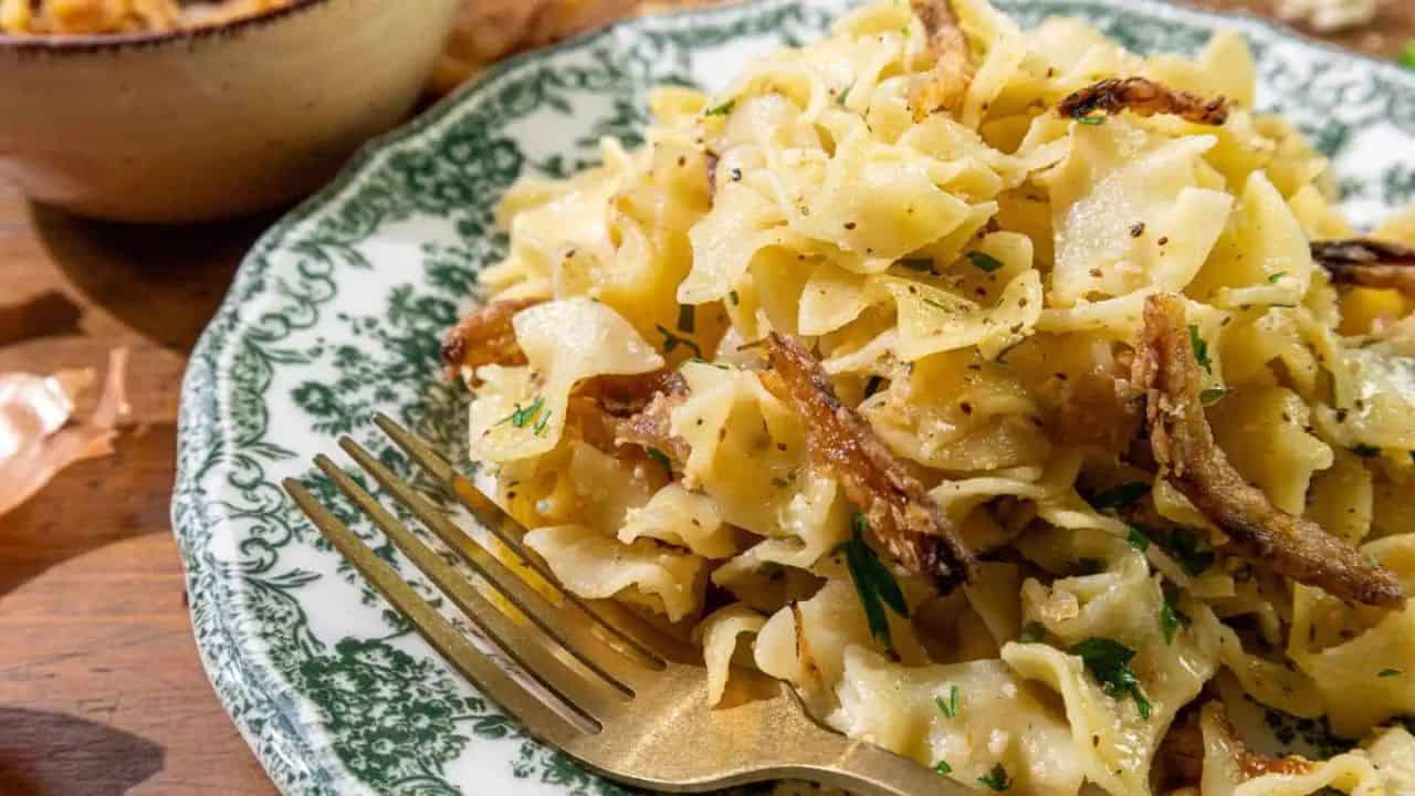 A bowl filled with French onion noodle casserole and a side of meatballs.