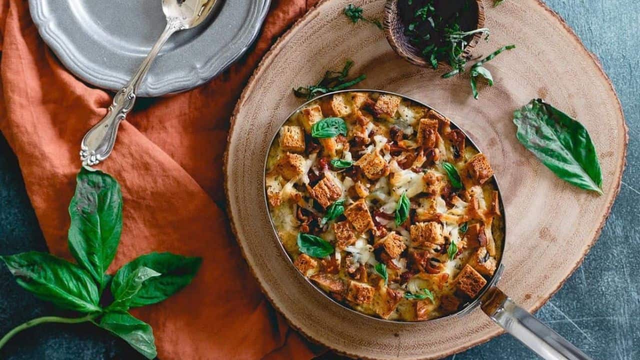 Everything bagel strata in metal baking dish on wooden surface.