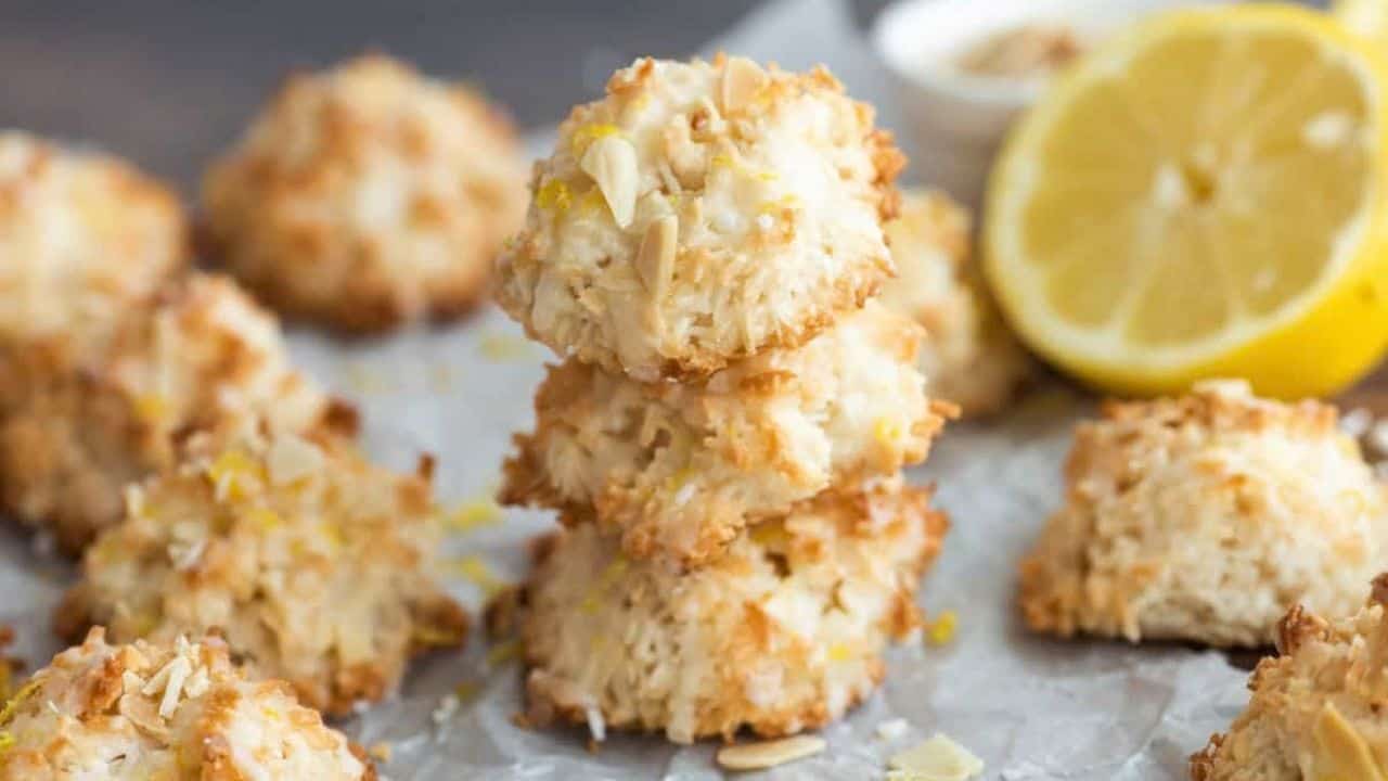 Low angle shot of lemon coconut macaroons on a parchment paper lined baking sheet.