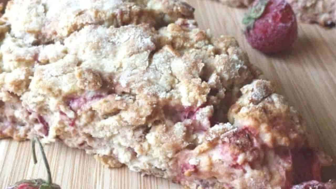 Image shows an overhead shot of Strawberry bacon scones on a wooden cutting board.