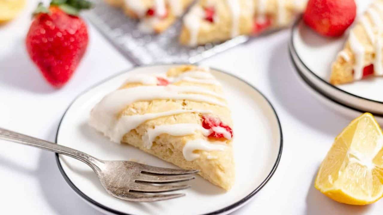 A plate with a scone and a fork on it.